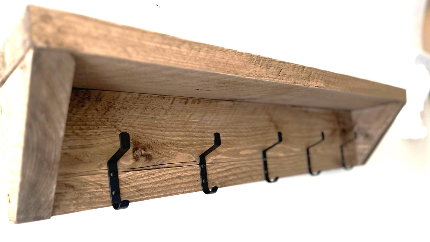 Farmhouse style wooden shelf with hooks on a white background