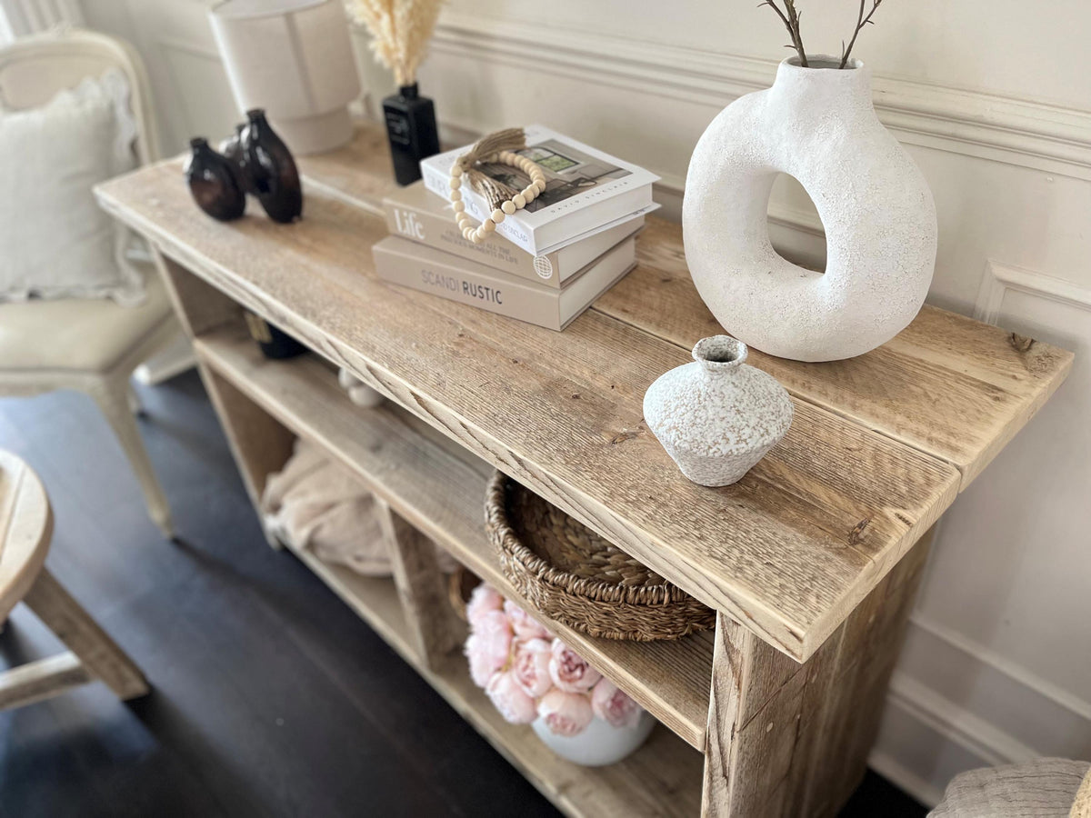 Wooden console table with decorative items in a living room setting