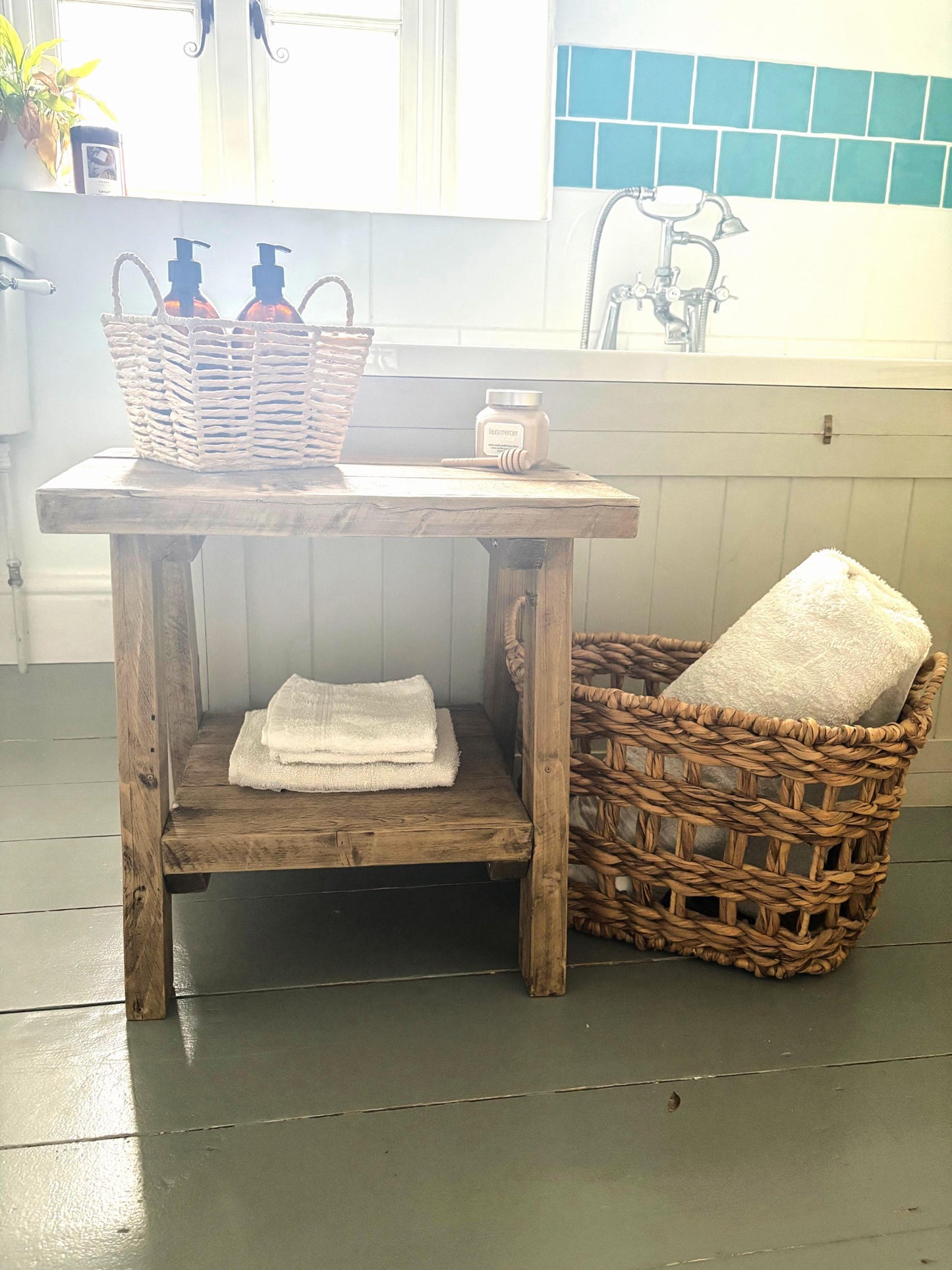 Bathroom setting with a rustic wooden  side table that includes a bottom shelf.  