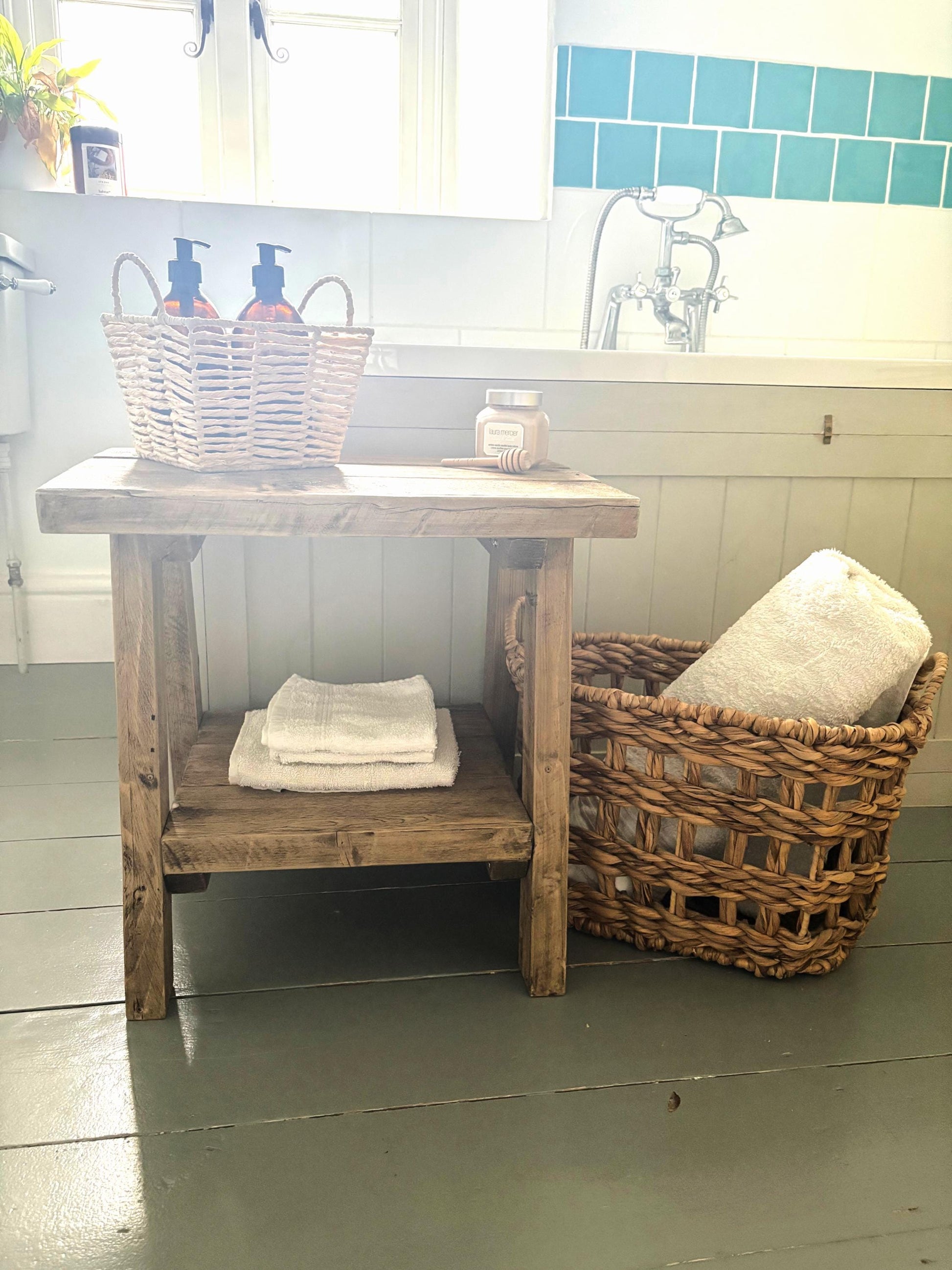 Bathroom setting with a rustic wooden  side table that includes a bottom shelf.  