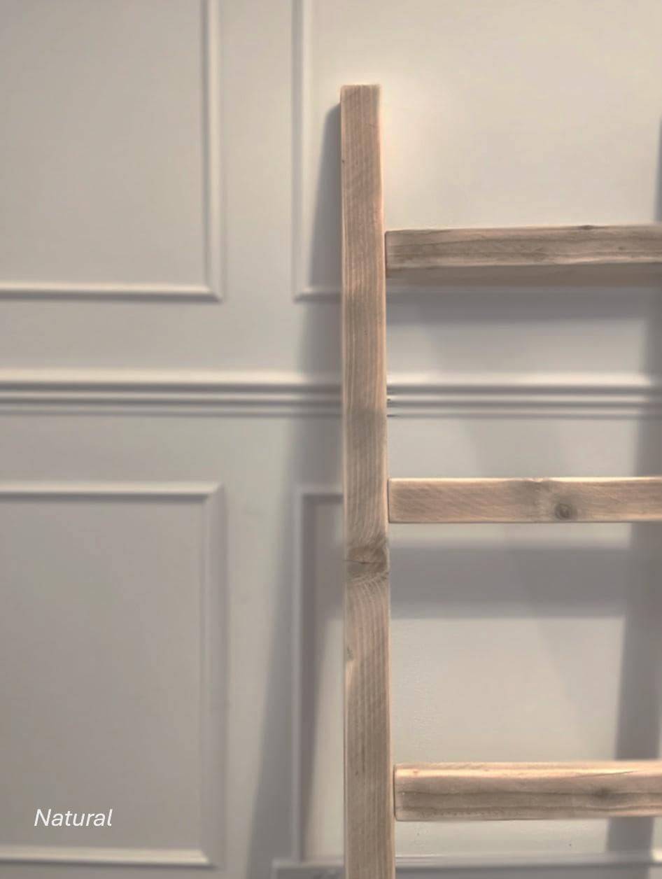 Rustic wooden ladder against a light gray paneled wall