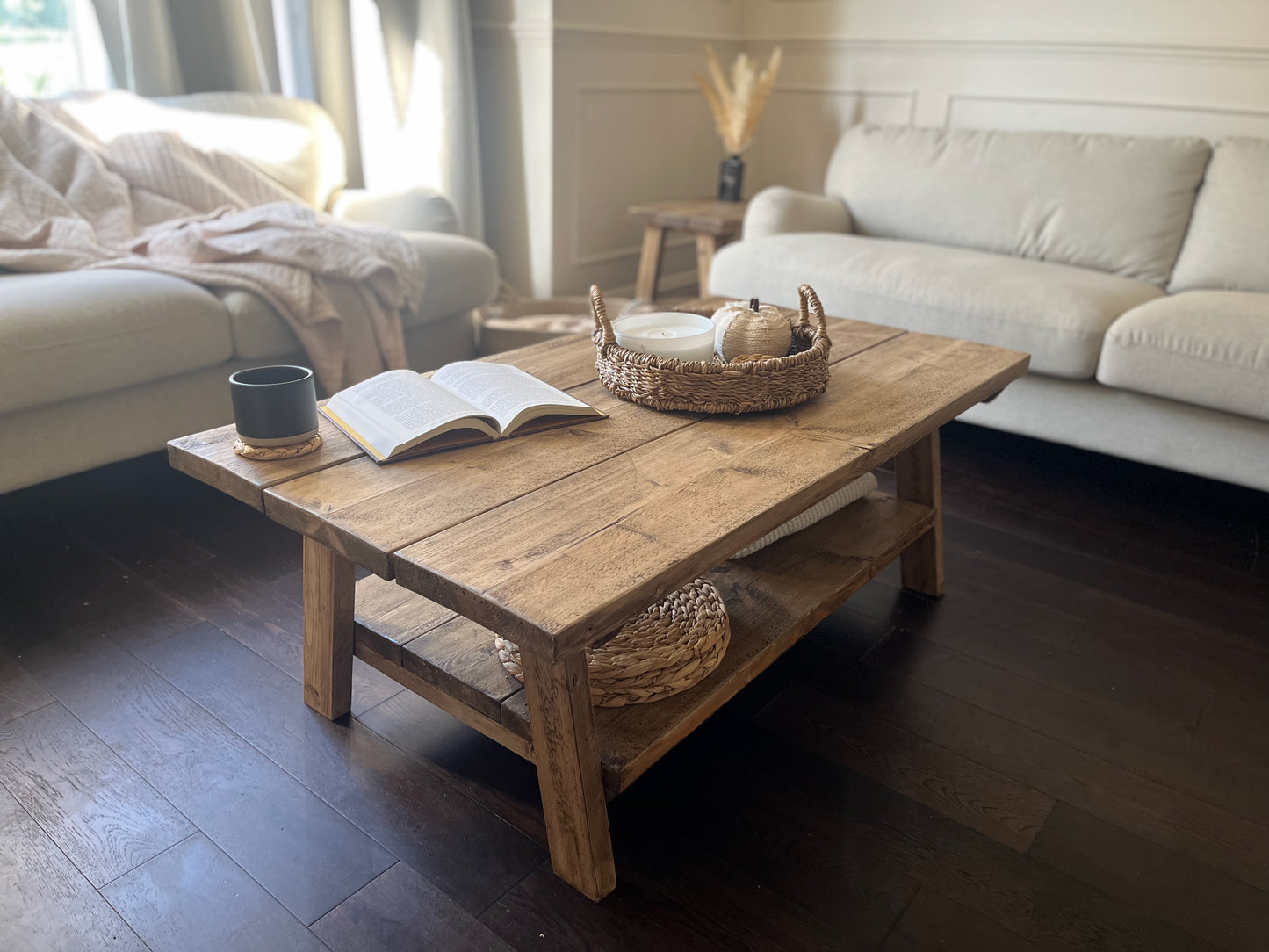 A farmhouse styled, rustic wooden coffee table, with a lower shelf in a living room setting.