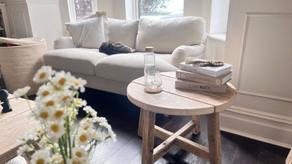 Living room with a white sofa, wooden coffee table, and decorative items.
