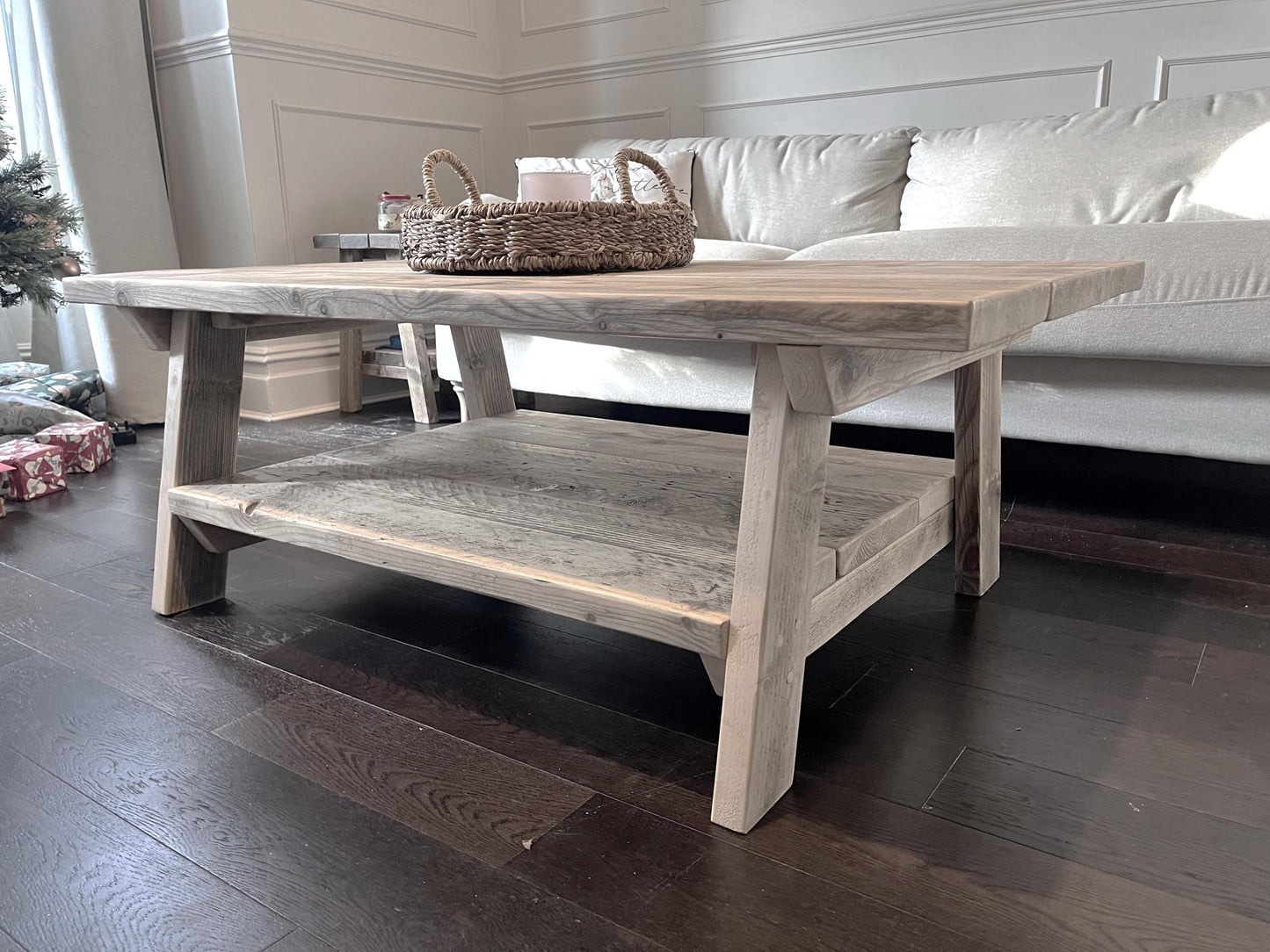 A farmhouse styled, rustic wooden coffee table, with a lower shelf in a living room setting.