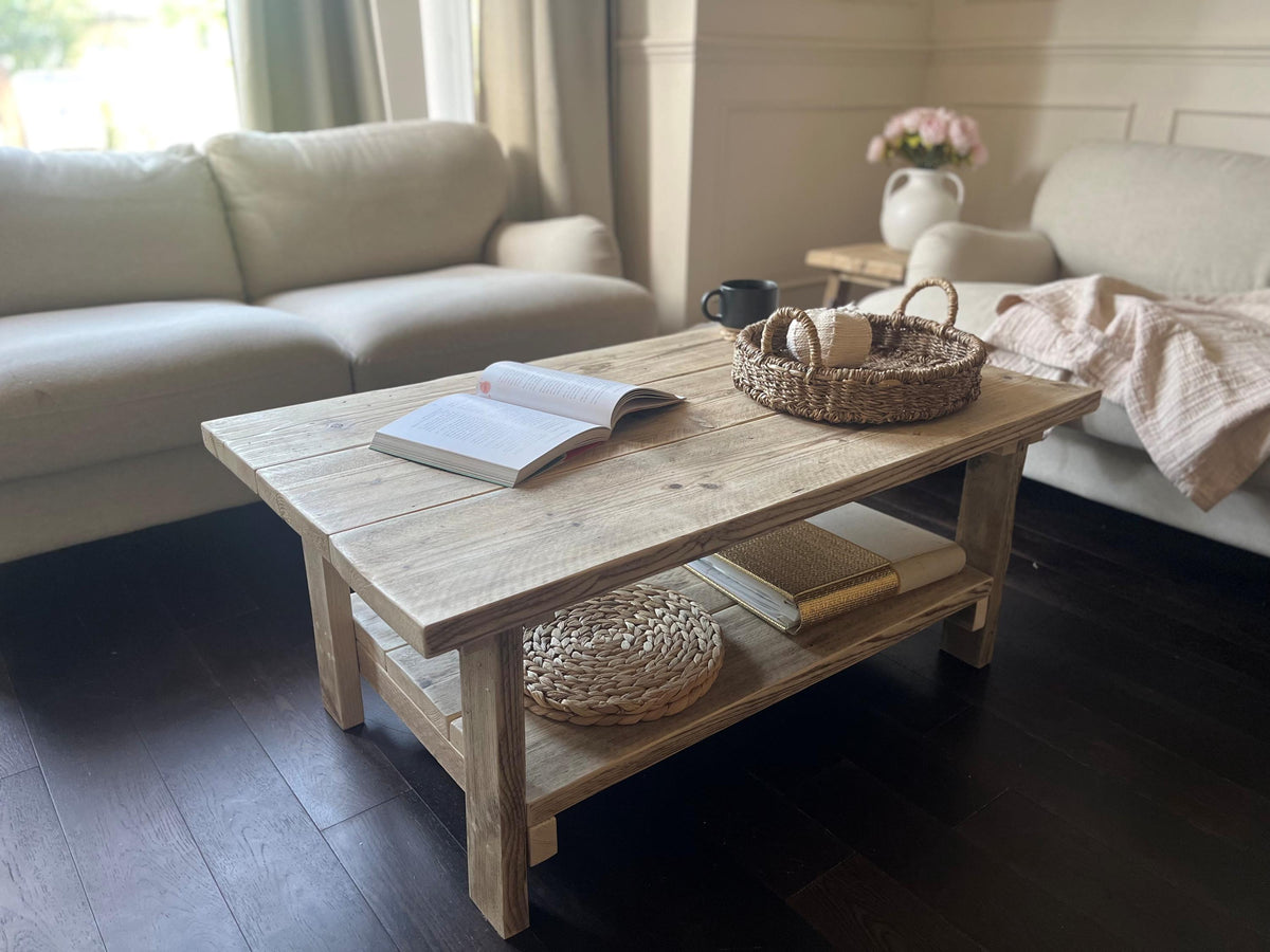 Farmhouse style wooden coffee table with books and a basket in a living room setting.