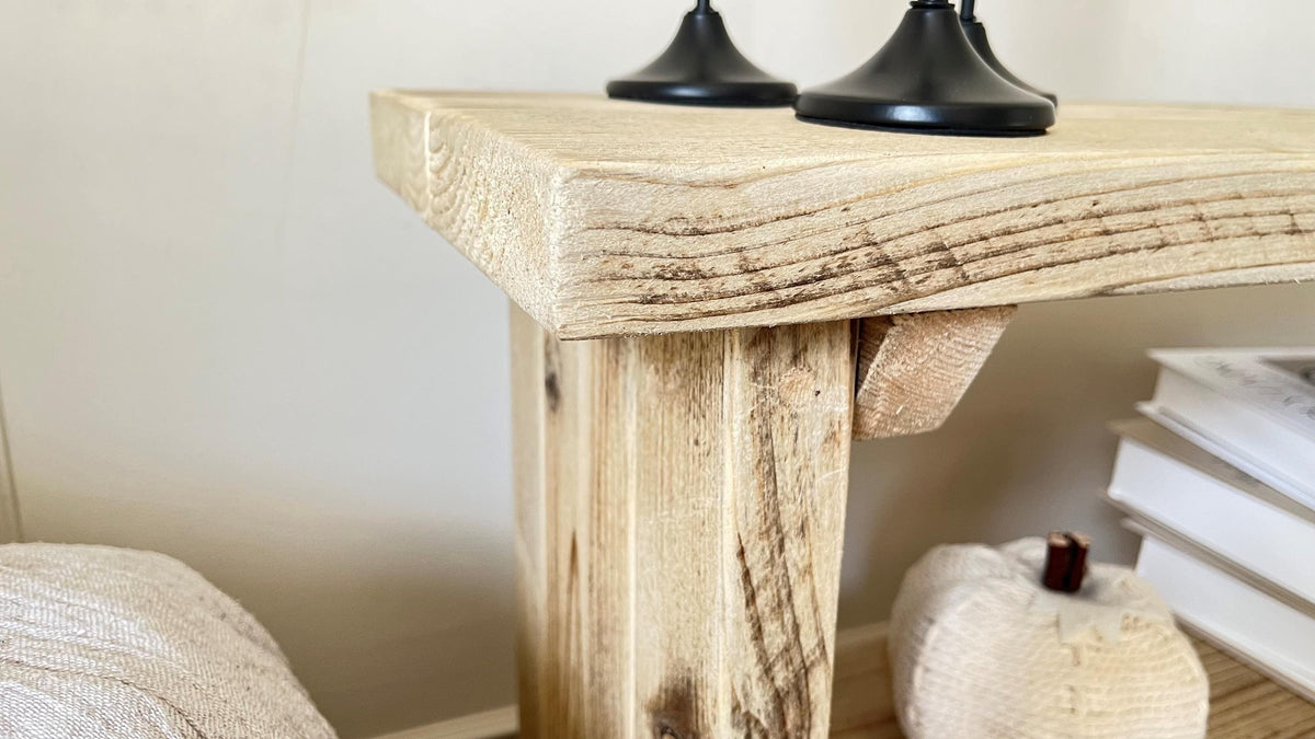 A farmhouse styled, rustic wooden bookcase, in a living room setting. (top corner view)