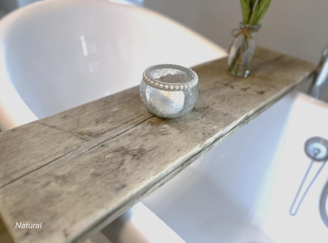 A wooden bath tray with a decorative candle holder and small plant in a bathroom setting.