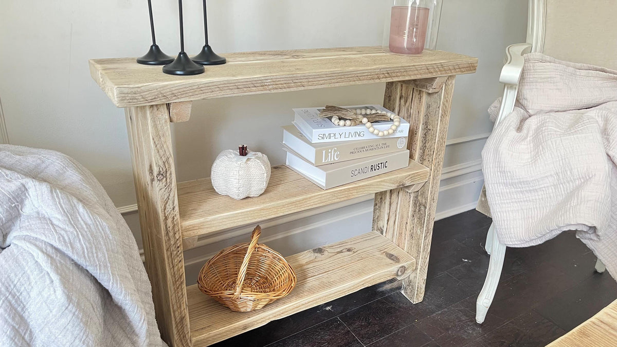 A farmhouse styled, rustic wooden bookcase, in a living room setting. (front view)