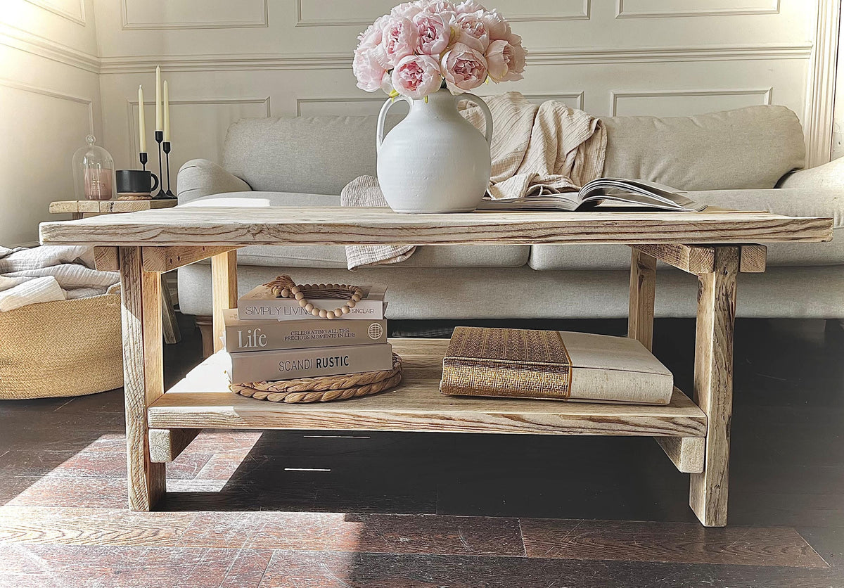 A farmhouse styled, rustic wooden coffee table with decorative items in a living room setting.