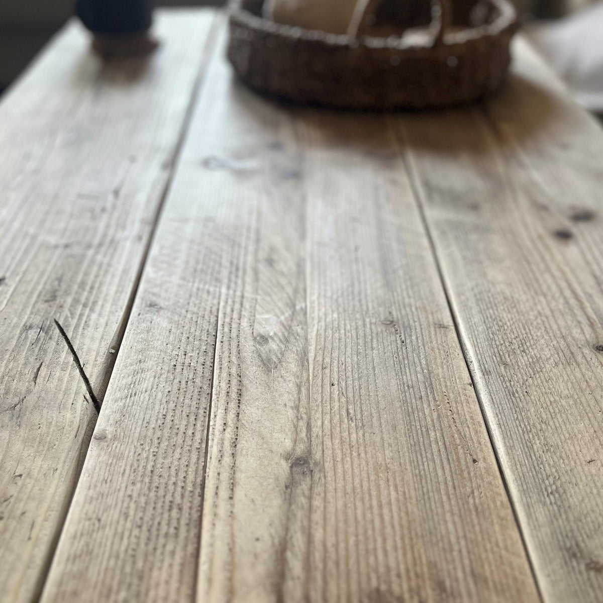 Close-up of a wooden surface with a basket in the background