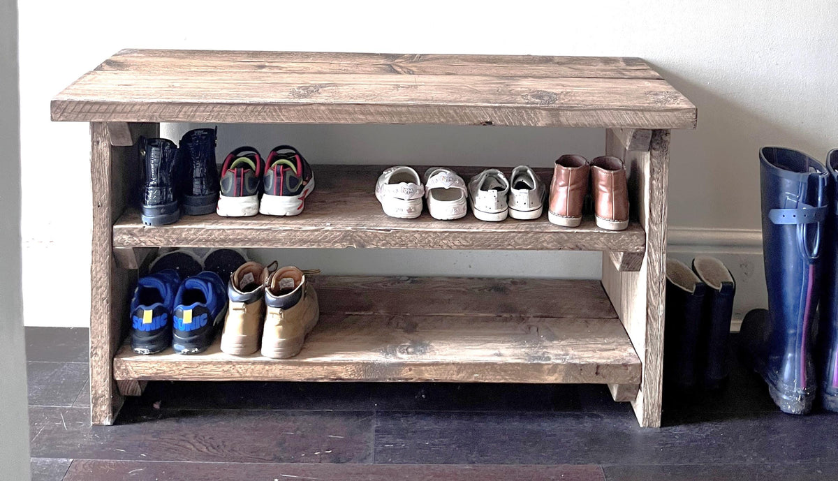 A farmhouse styled, rustic wooden show rack, in a entryway setting. (front view)