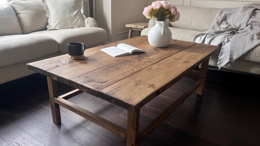 A farmhouse style wooden dark coffee table with a bottom shelf, in a living room setting (front view)