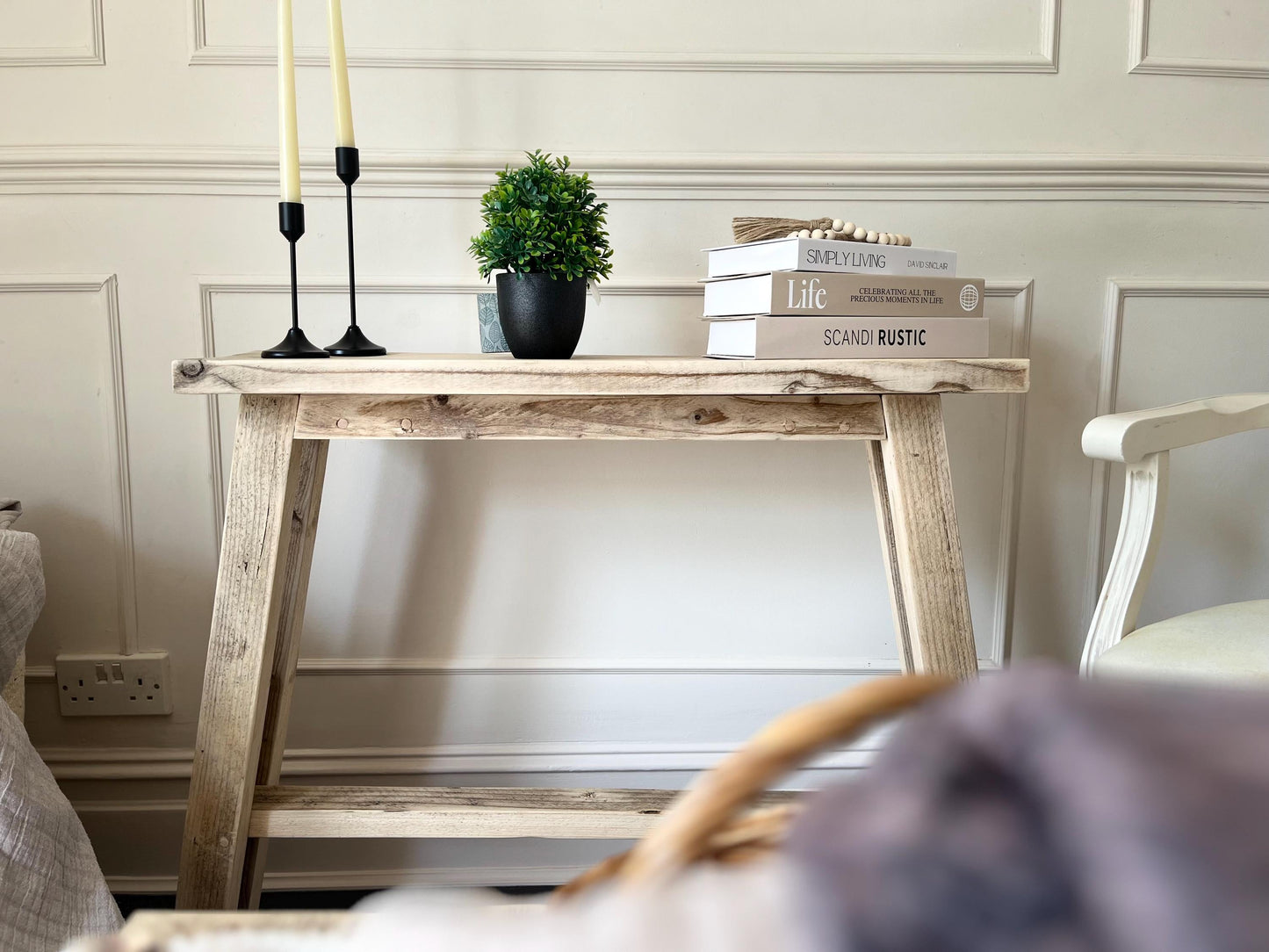 A farmhouse style rustic wooden slim console table with a bottom shelf, in a living room setting (front view)