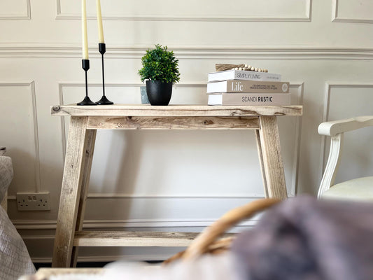 A farmhouse style rustic wooden slim console table with a bottom shelf, in a living room setting (front view)