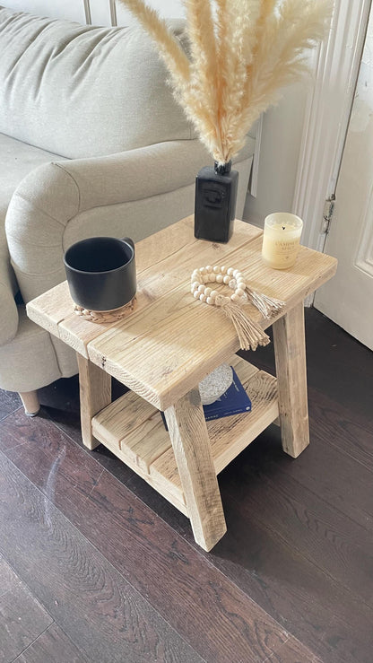 A rustic style wooden side table with a bottom shelf, in a living room setting (top view)