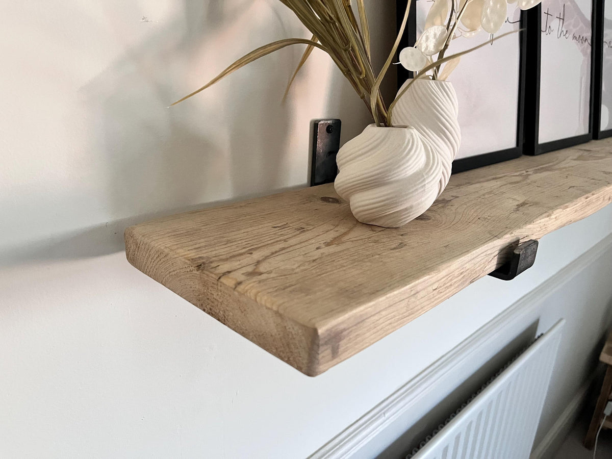 Wooden shelf with a decorative vase and plant on a white surface